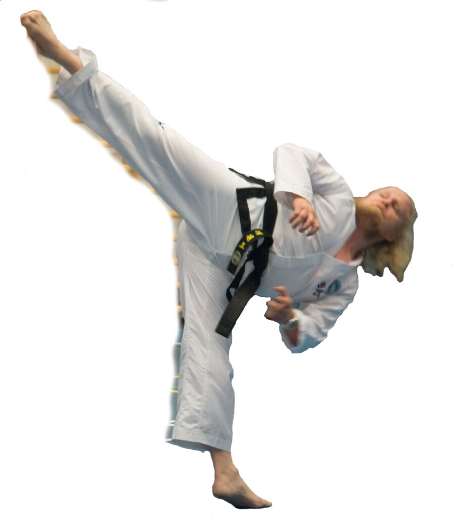 Taekwon-Do-harrastaja korkeassa sivupotkussa, mustavyö dobokissa