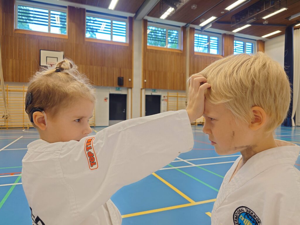Kaksi lasta harjoittelemassa vierekkäin salissa