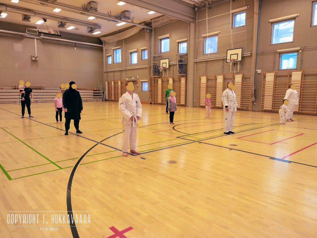 Harjoitusryhmä seisoo salissa rivissä